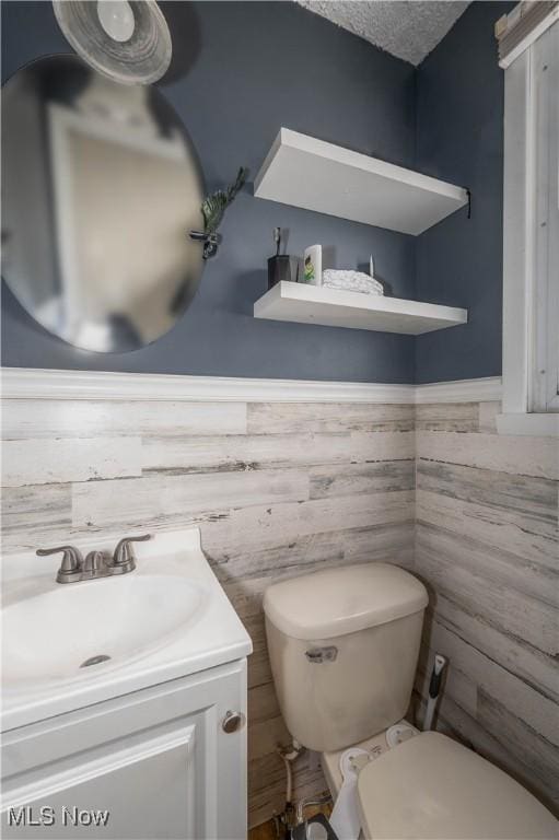 bathroom featuring vanity, a textured ceiling, and toilet