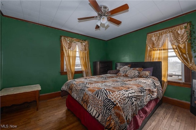 bedroom with crown molding, hardwood / wood-style floors, and ceiling fan