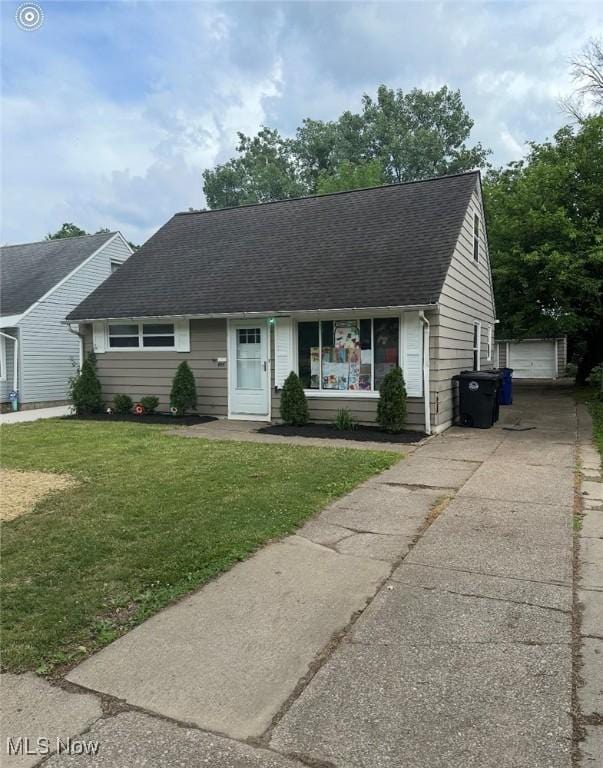 ranch-style home featuring a garage, an outbuilding, and a front yard