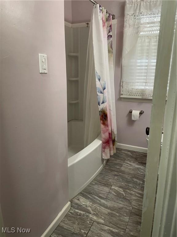 bathroom with shower / bath combo with shower curtain