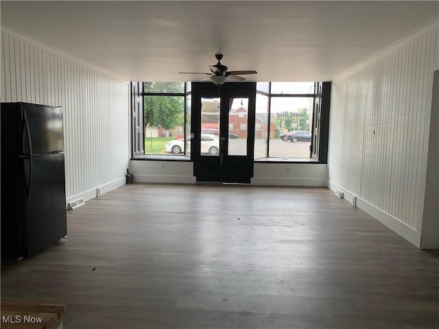 spare room with a wealth of natural light, wood-type flooring, and ceiling fan