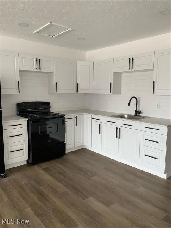 kitchen featuring white cabinetry, sink, black range with electric cooktop, dark wood-type flooring, and a textured ceiling