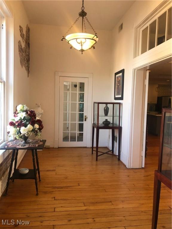 doorway to outside with a high ceiling and light wood-type flooring