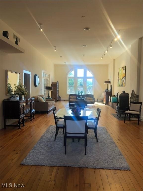 dining space with rail lighting and hardwood / wood-style floors