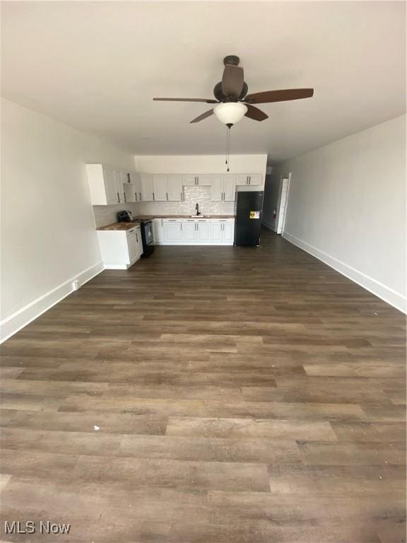 unfurnished living room with ceiling fan, dark hardwood / wood-style floors, and sink