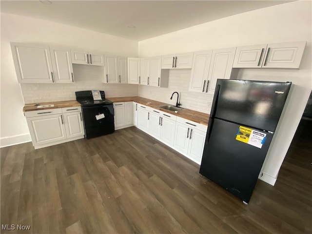 kitchen with butcher block countertops, sink, black appliances, and white cabinets