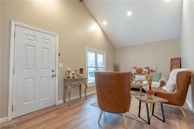 living area featuring high vaulted ceiling and light wood-type flooring