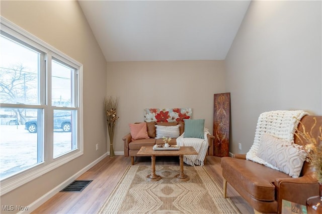 sitting room featuring lofted ceiling, plenty of natural light, and light hardwood / wood-style flooring