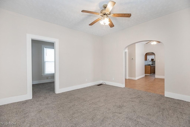 carpeted empty room with a textured ceiling and ceiling fan