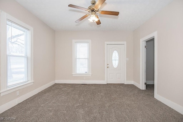 foyer entrance featuring baseboards, carpet flooring, and a healthy amount of sunlight