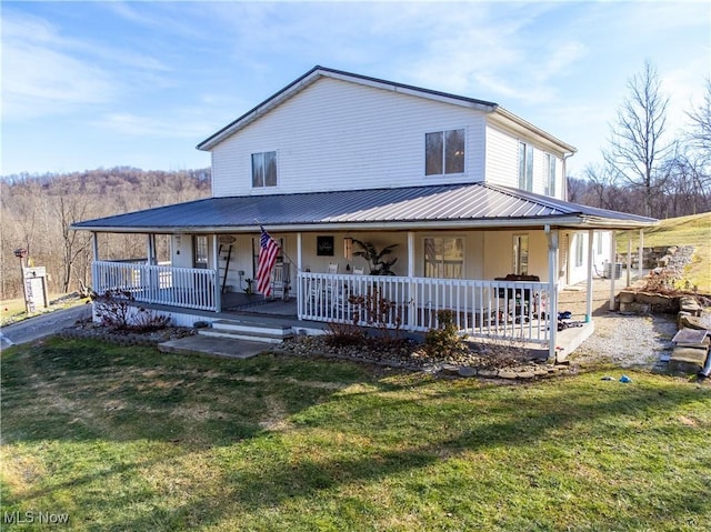 view of front of home with covered porch, metal roof, and a front yard