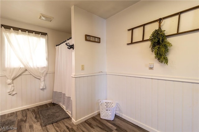 interior space with dark wood-style flooring and wainscoting