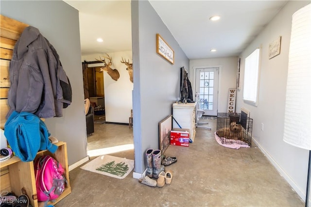 interior space featuring baseboards, concrete flooring, and recessed lighting