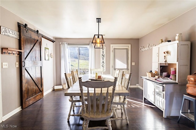 dining room featuring dark wood-style floors, a barn door, and baseboards