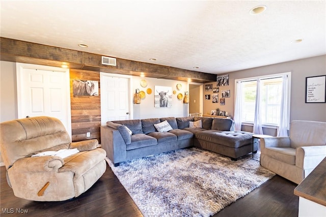 living room with dark wood-style floors, visible vents, and a textured ceiling