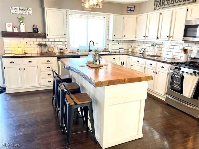 kitchen with appliances with stainless steel finishes, white cabinets, and a center island