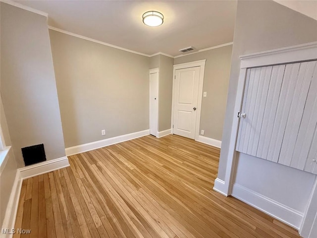 unfurnished bedroom featuring ornamental molding, light hardwood / wood-style floors, and a closet