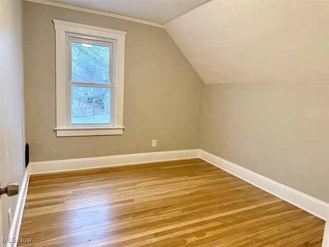 bonus room with vaulted ceiling and light wood-type flooring