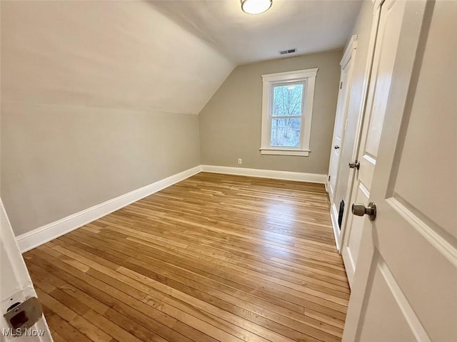 additional living space featuring lofted ceiling and light hardwood / wood-style floors