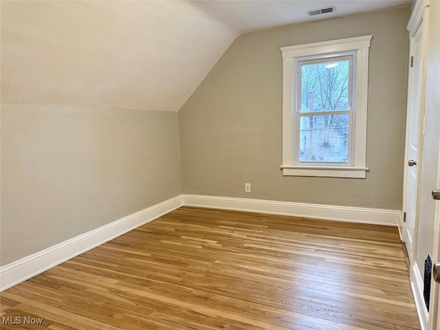 additional living space with lofted ceiling and light hardwood / wood-style flooring