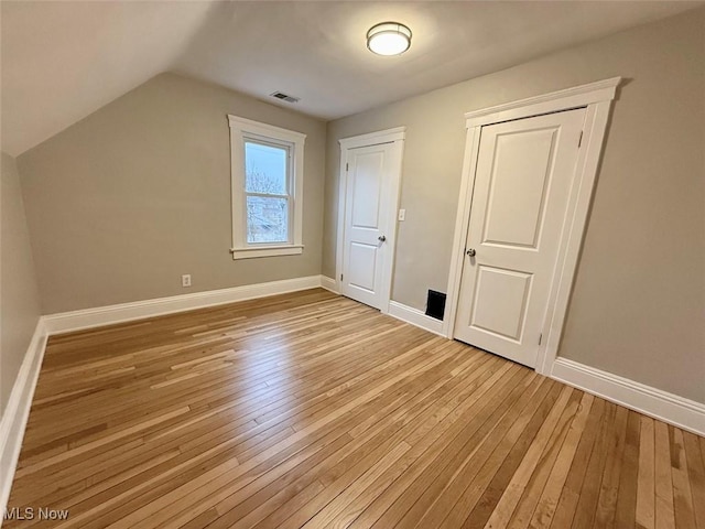 additional living space with vaulted ceiling and light hardwood / wood-style floors