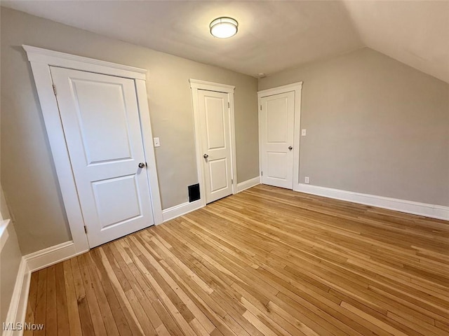 additional living space featuring lofted ceiling and light hardwood / wood-style floors