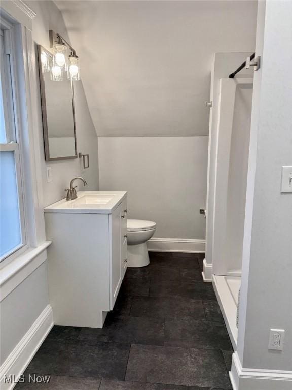 bathroom featuring walk in shower, vanity, toilet, and vaulted ceiling