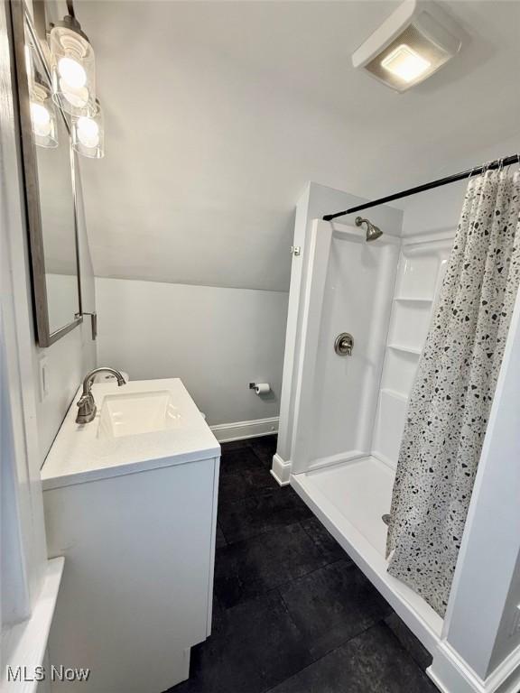 bathroom with lofted ceiling, vanity, and a shower with curtain