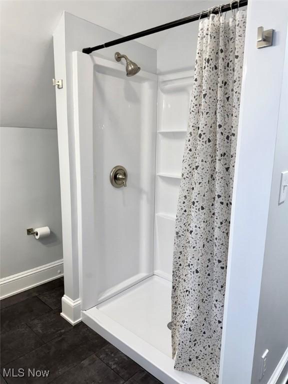 bathroom featuring lofted ceiling and a shower with curtain