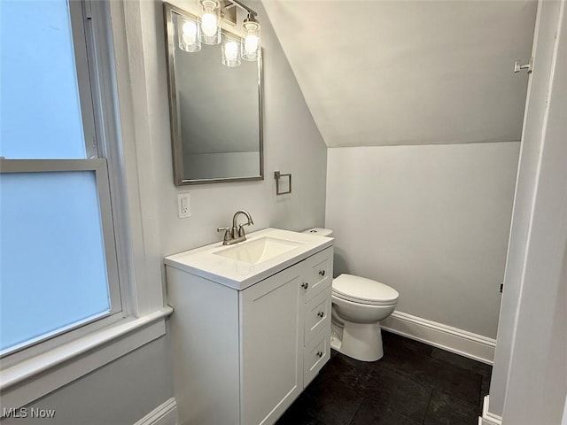 bathroom featuring vanity, vaulted ceiling, and toilet