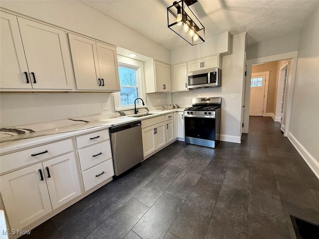 kitchen featuring sink, a textured ceiling, stainless steel appliances, and white cabinets