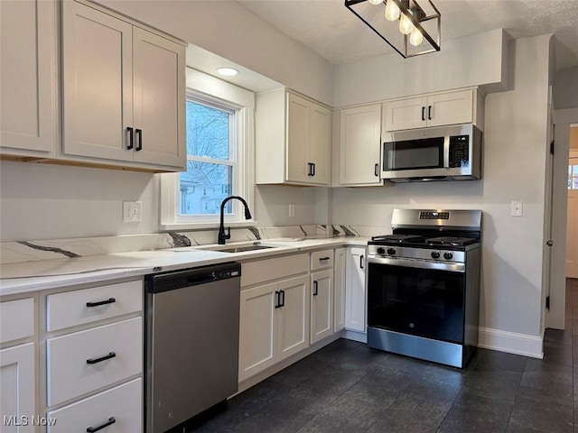 kitchen with stainless steel appliances, light stone countertops, sink, and white cabinets