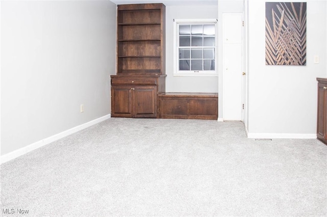unfurnished living room with light colored carpet