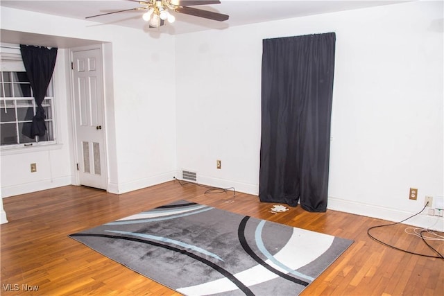 exercise area featuring dark hardwood / wood-style flooring and ceiling fan