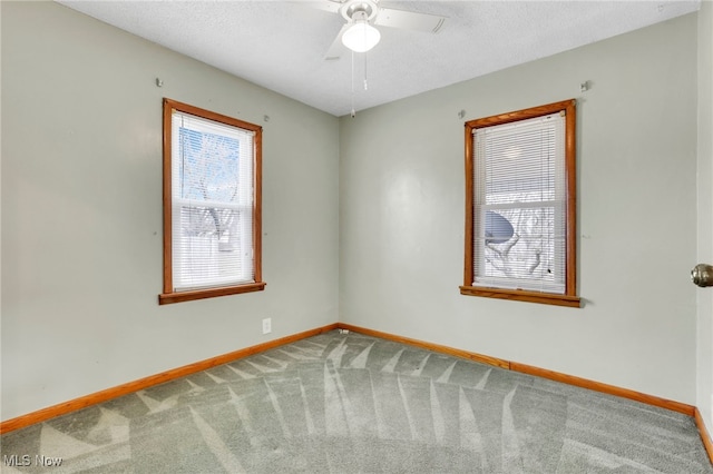 carpeted empty room with ceiling fan and a textured ceiling