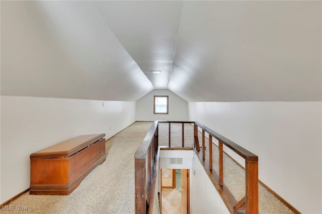 interior space featuring vaulted ceiling and light carpet