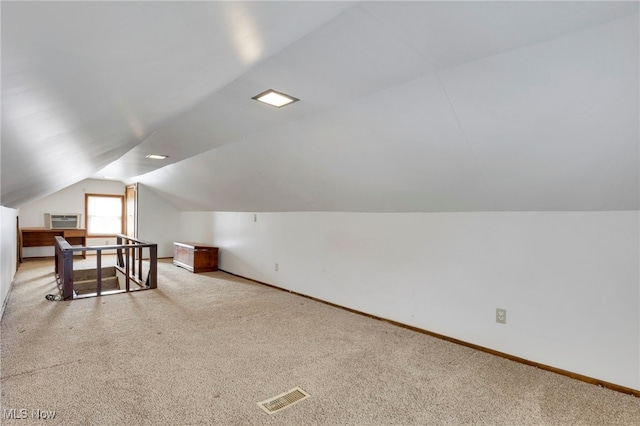 bonus room featuring lofted ceiling, carpet floors, and a wall mounted air conditioner