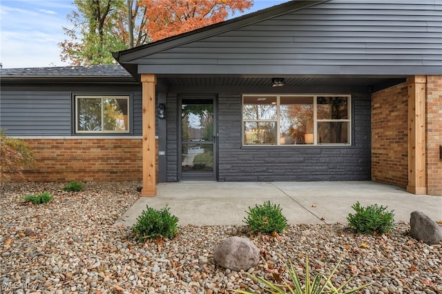 view of exterior entry with a patio area