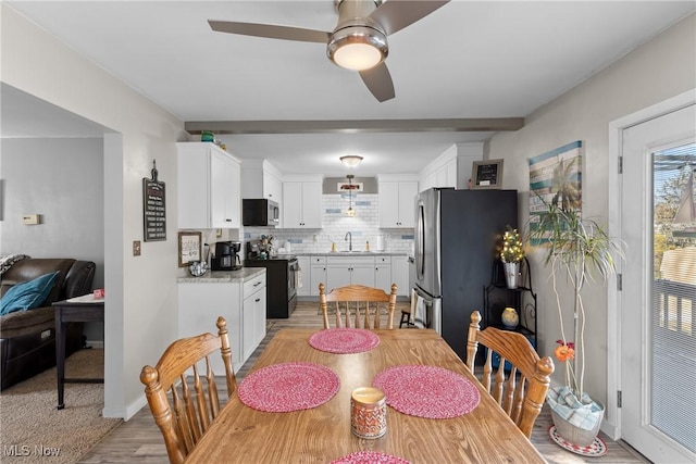 dining space featuring sink, ceiling fan, and light wood-type flooring