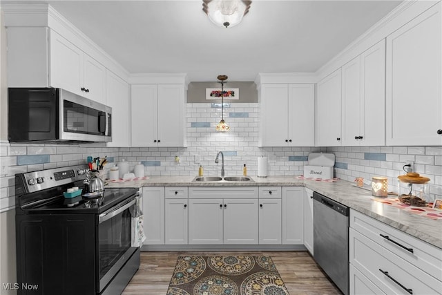 kitchen featuring pendant lighting, sink, stainless steel appliances, and white cabinets