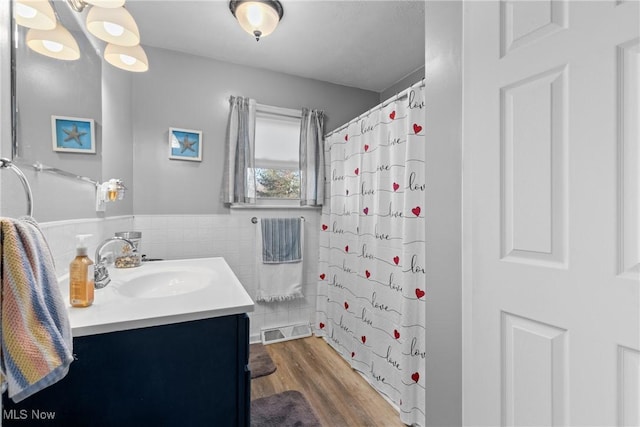 bathroom featuring vanity, hardwood / wood-style flooring, tile walls, and walk in shower