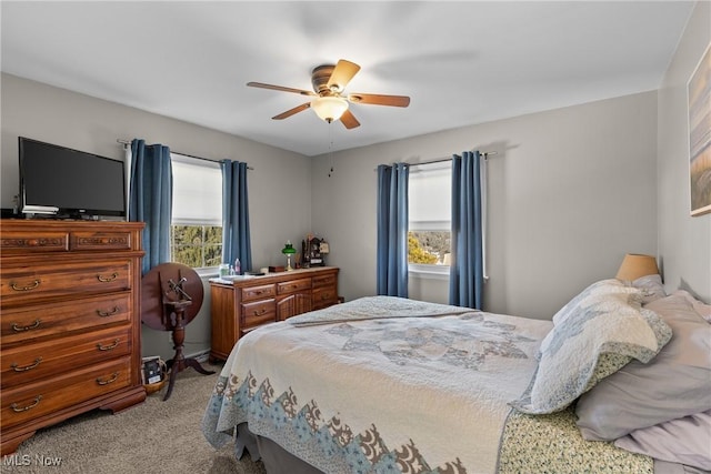 carpeted bedroom with ceiling fan and multiple windows