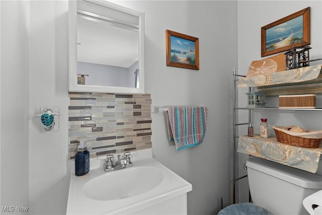 bathroom with sink, decorative backsplash, and toilet