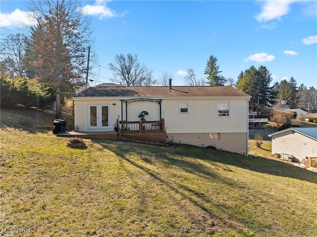 back of property featuring french doors, a yard, a deck, and a fire pit