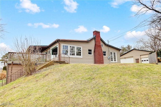 rear view of house with an outbuilding, a garage, and a lawn