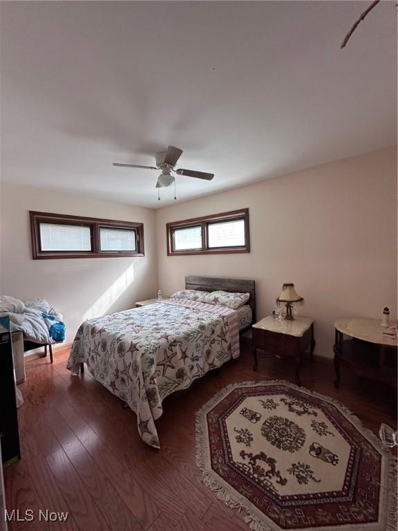 bedroom with dark hardwood / wood-style floors and ceiling fan