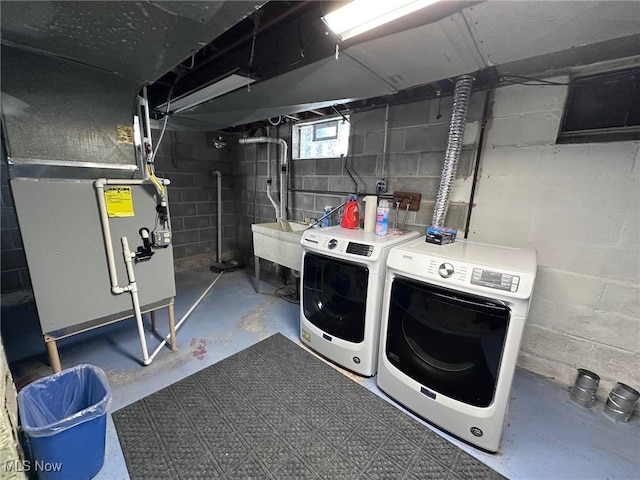 washroom featuring heating unit, sink, and washer and dryer