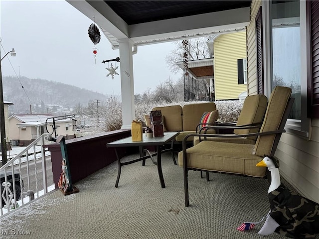 snow covered back of property with a mountain view