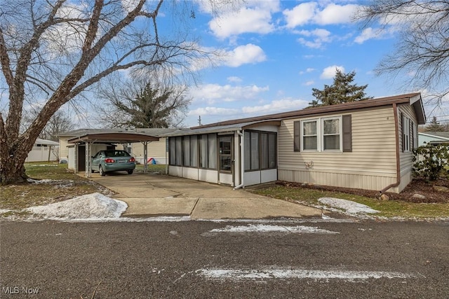 manufactured / mobile home featuring a carport and a sunroom