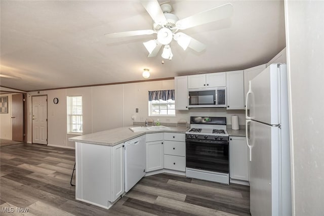 kitchen featuring sink, white appliances, white cabinets, dark hardwood / wood-style flooring, and kitchen peninsula